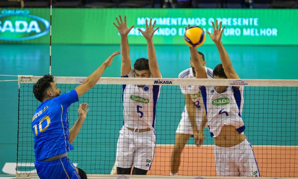 Nicolas, do Vôlei Renata, ataca a bola. Jogadores do Sada Cruzeiro tentam bloquear a jogada