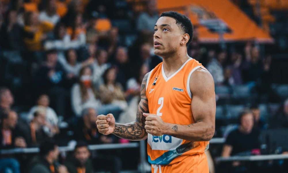 Yago - comapnheiro de time de bruno Cabloco - ergue os braços e comemora cesta na Eurocup de basquete