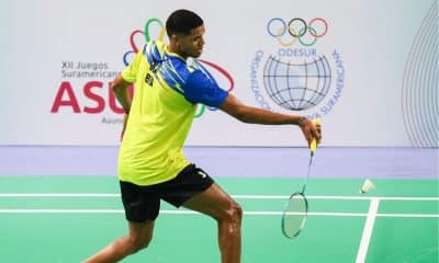 Davi Silva enquanto joga no Pan-Americano de badminton. Ele veste shorts preto e camiseta amarela e segura a raquete na mão direita