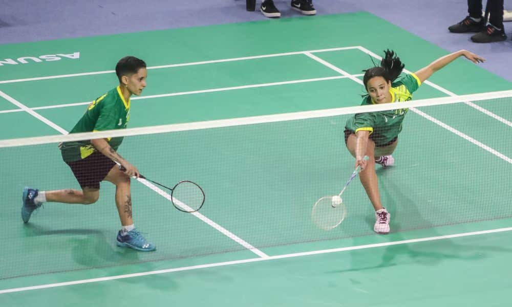 Sania Lima e Juliana Vieira perderam nas oitavas de final do Aberto dos Estados Unidos. Na foto, elas jogam em uma quadra verde clara e vestem shorts pretos com camiseta verde