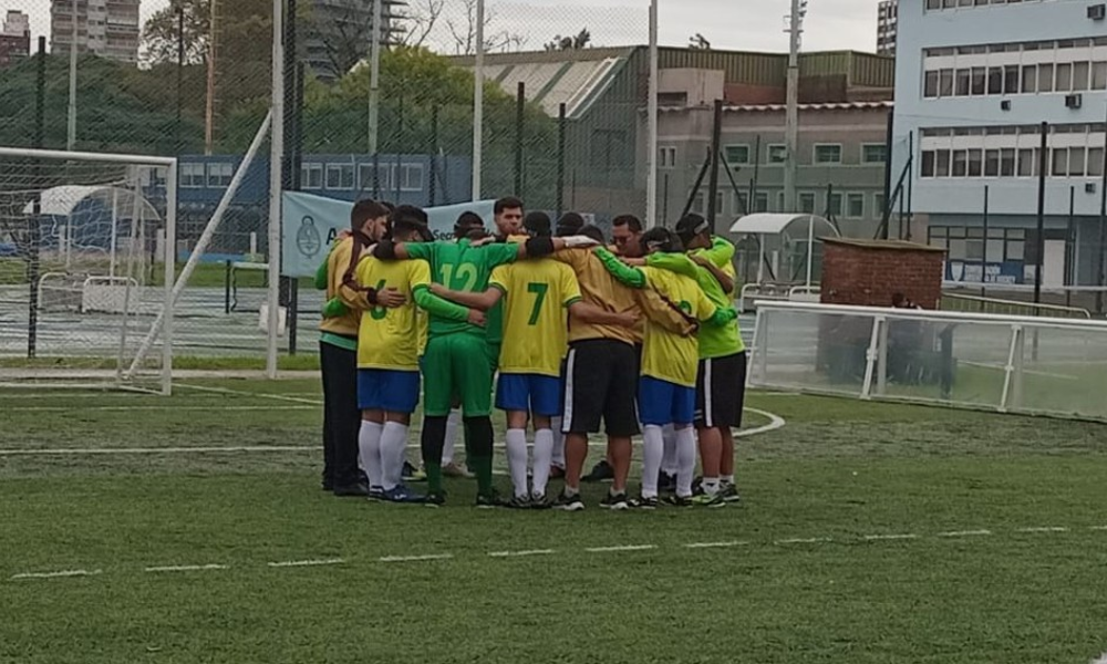 Garotos do Brasil e comissão técnica estão abraçados em um círculo em uma das áreas do campo do Cenard, palco dos jogos da Copa Tango 2024. Foto: Divulgação/ Fadec.