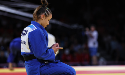 Natasha Ferreira no tatame após derrota em Paris-2024; ela tem consolo do filho