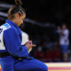 Natasha Ferreira no tatame após derrota em Paris-2024; ela tem consolo do filho