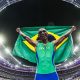 Alison dos Santos comemora com a bandeira do Brasil a conquista da medalha de bronze nos 400 m com barreiras nos Jogos Olímpicos de Paris-2024