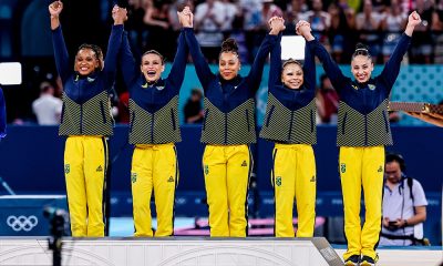 Na imagem, Flávia Saraiva com Jade Barbosa e o restante da equipe de ginástica artística brasileira antes de subir ao pódio.