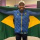 Claudiney Santos comemora com a bandeira do Brasil o tricampeonato paralímpico do lançamento de disco F56