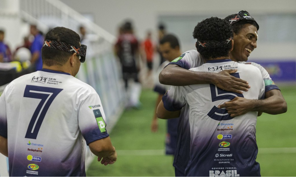 Ezequiel é abraçado por Jonatas Macena, que está de costas para a imagem e traz o número 7 na camisa. Ao lado deles, Liwisgton se aproxima. Fotos: Taba Benedicto/ CBDV.