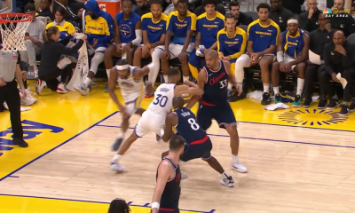 Frame da lesão de Stephen Curry. Gui Santos assiste do banco de reservas, na NBA, Warriors