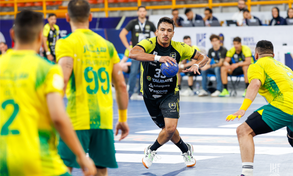 Jogador do Taubaté segura a bola enquanto é marcado por três atletas do Al Khaleej no Mundial de Clubes de handebol masculino