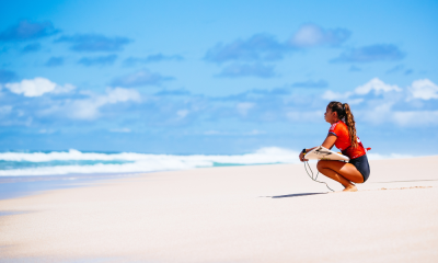 Bettylou Sakura Johnson na areia olhando para o mar em Pipeline